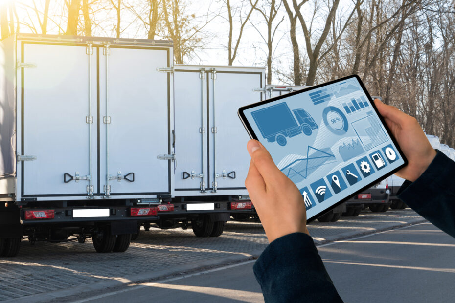 Manager with a digital tablet on the background of trucks. Fleet management